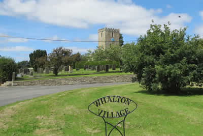 Whalton Village sign with St Mary Magdalene's Church in background